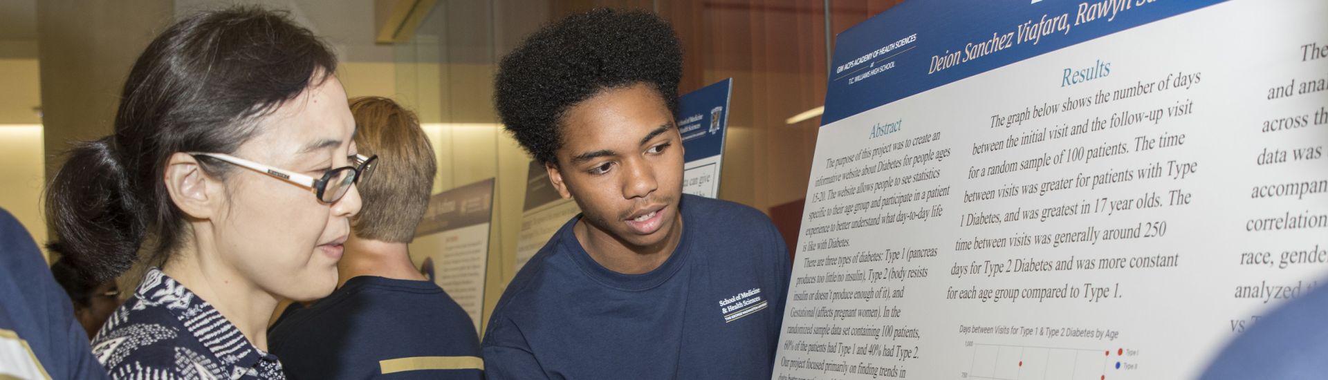 Student showing an adult a research poster